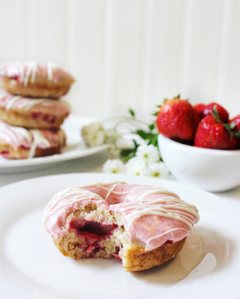 Strawberry donuts, pink frosting, bowl of strawberries