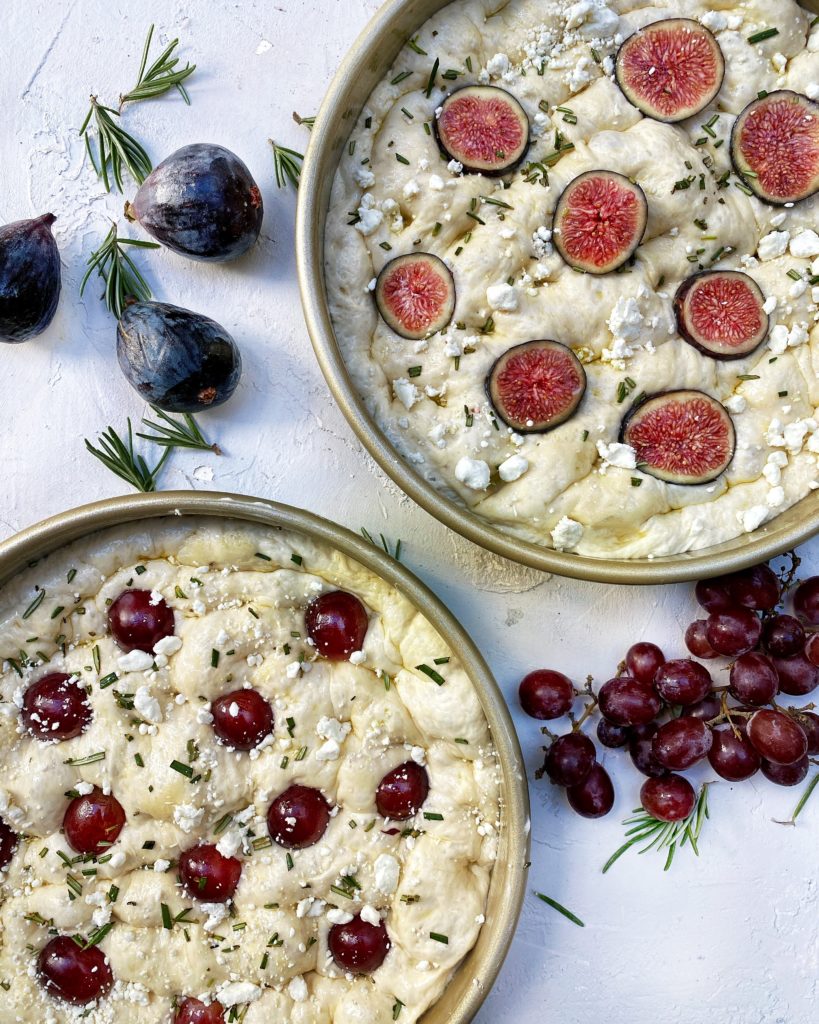 Unbaked focaccia with red grapes, fig, goat cheese, rosemary and honey