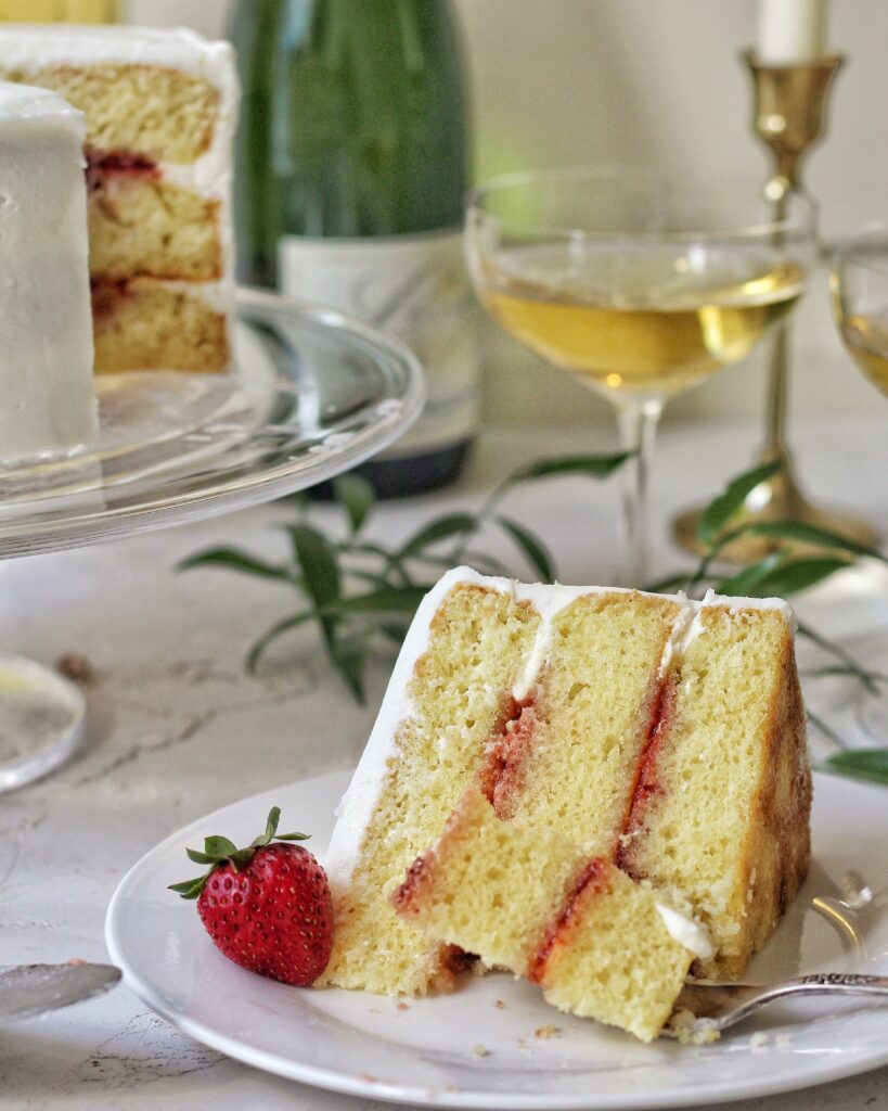 Slice of Champagne elderflower cake with strawberry preserves