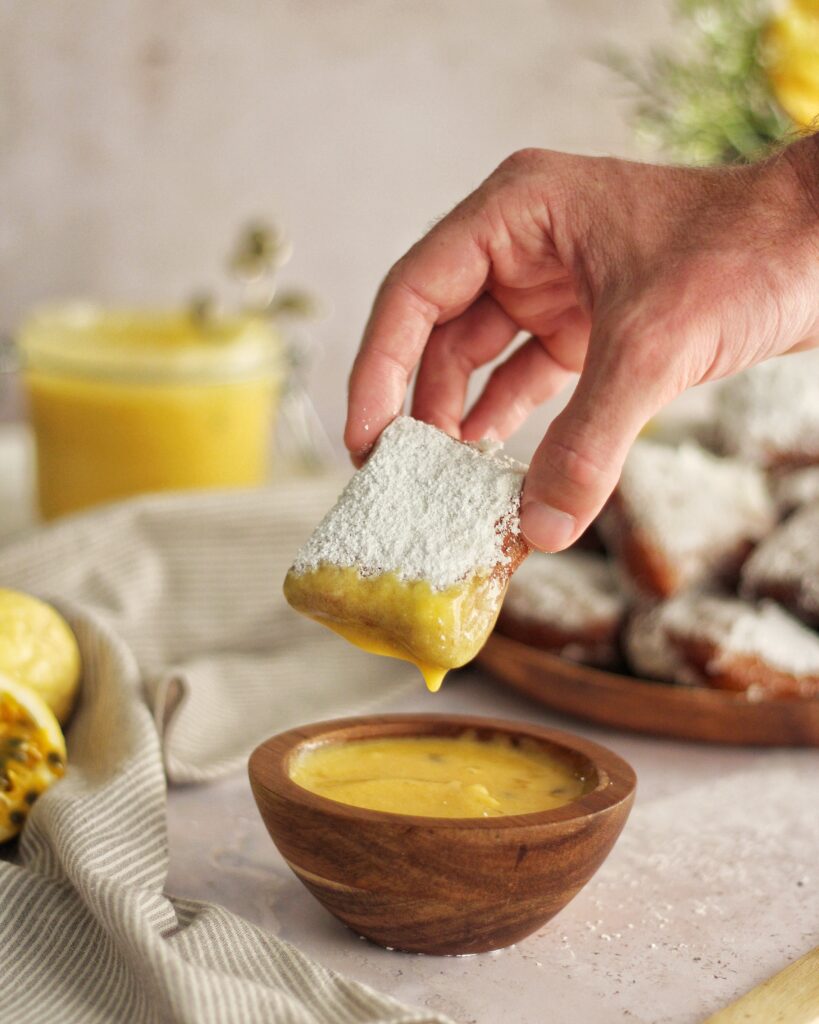 Dipping beignet into lilikoi curd