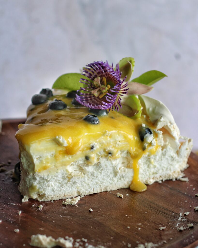 Slice of pavlova cake with passion fruit curd 