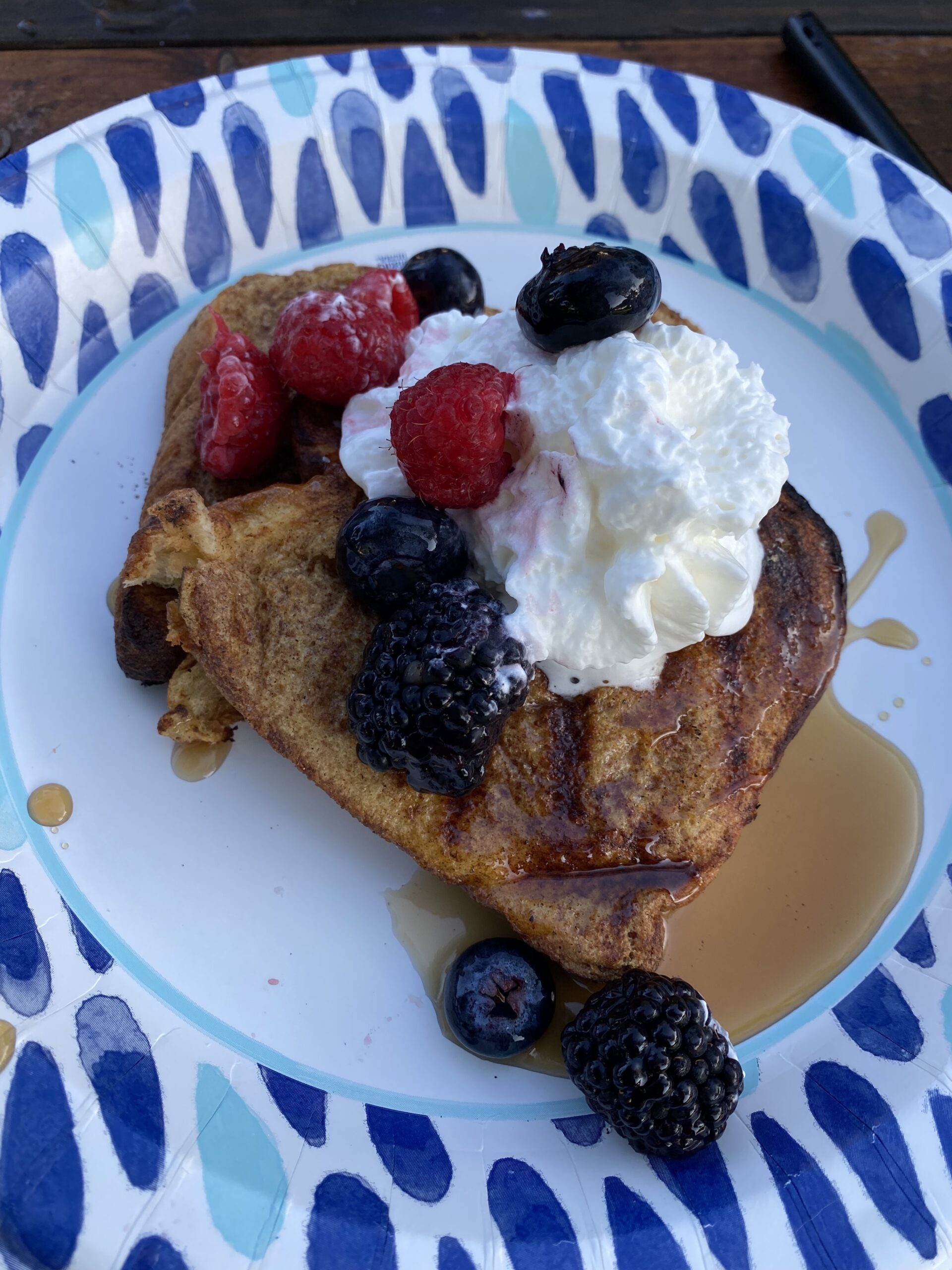 Grilled french toast with maple syrup, whipped cream, and fresh berries 